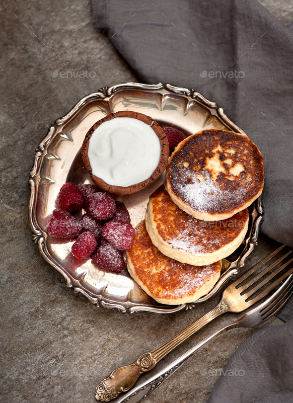 cottage cheese pancakes with sour cream and raspberries - Stock Photo - Images