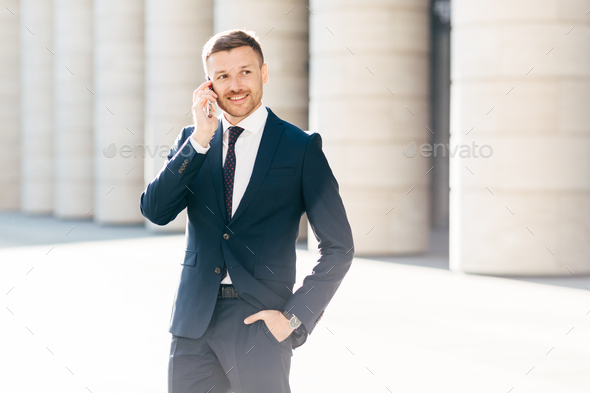 Successful male manager satisfied with mobile tariffs, makes phone call, uses banking service - Stock Photo - Images