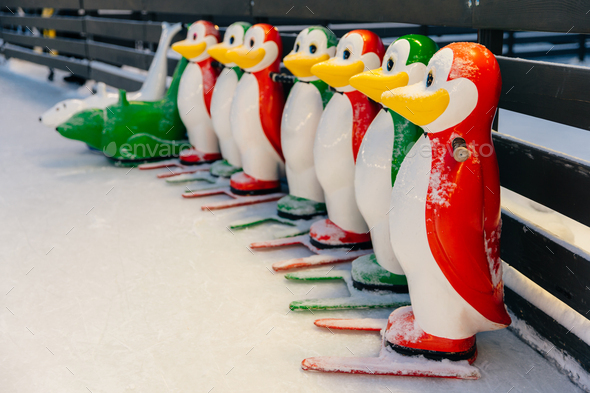 Colorful penguin figures used by skater beginners not to fall on ice covered with snow