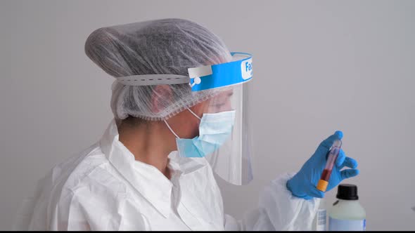 Doctor wearing protective clothing, doing blood test alt