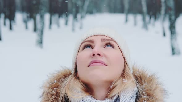 Close Up of Pacified Woman with Blue Eyes Looking in the Sky While Snowing