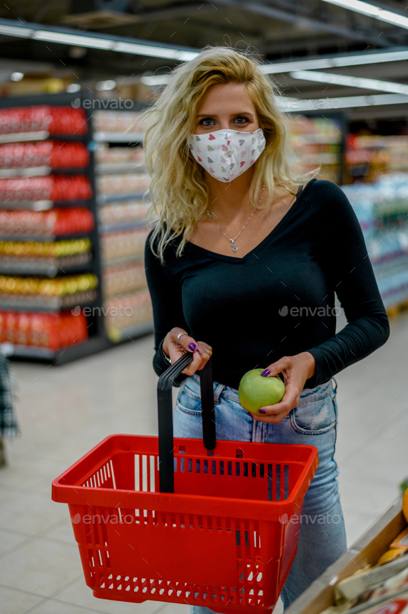 Woman in a supermarket wearing protective face mask while grocery shopping