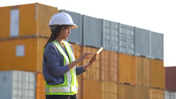 Worker woman checking and control loading containers box from cargo