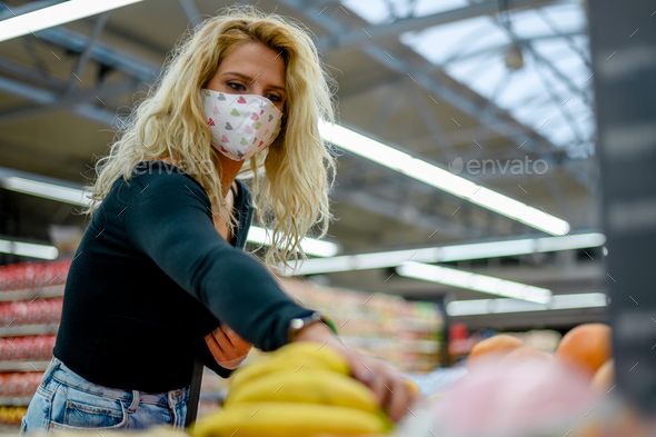 Woman in a supermarket wearing protective face mask while grocery shopping
