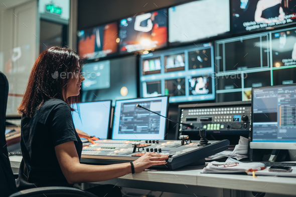 Young beautiful woman working in a broadcast control room on a tv station - Stock Photo - Images