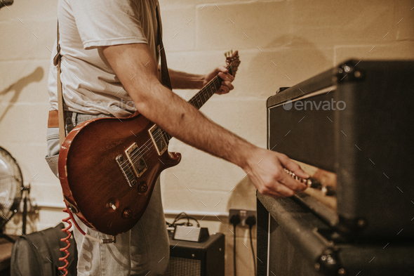 Musician setting guitar amp, studio recording session photo - Stock Photo - Images