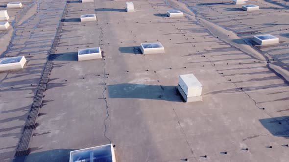 Aerial view of flat roof with equipment and windows after rain.