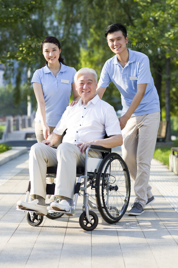 Wheelchair bound man with nursing assistants