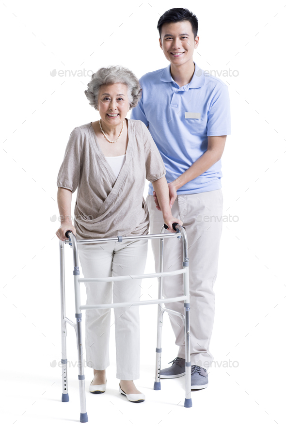 Male nursing assistant helping senior woman with walking frame