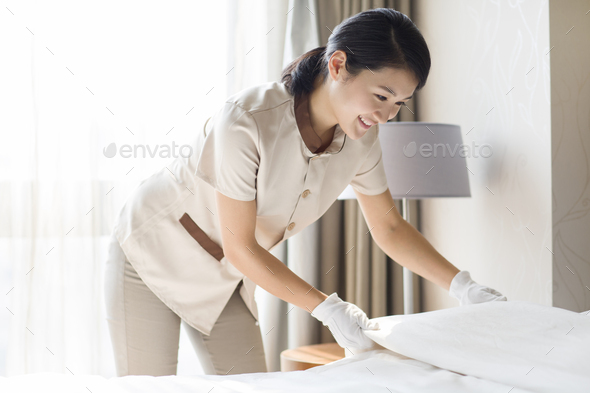 Domestic staff cleaning bedroom