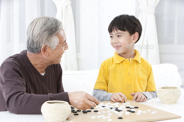 Grandpa and grandson playing Chinese Weiqi Stock Photo by bluejeanimages