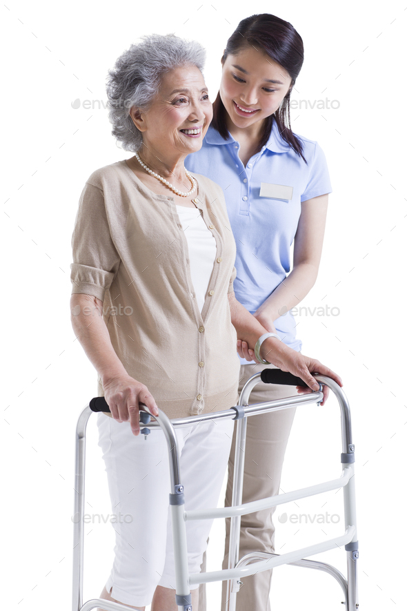 Female nursing assistant helping senior woman with walking frame