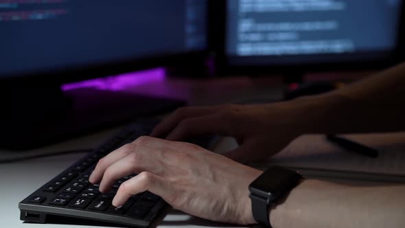 Young Programmer Works in Front of Computer Typing on Keyboard and Writing Notes in Macro alt