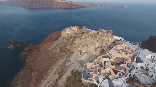 Aerial footage of Oia castle on Santorini Island in Greece during sunrise alt