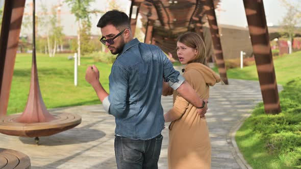 Young man walks with his girlfriend and looks at the black young woman alt