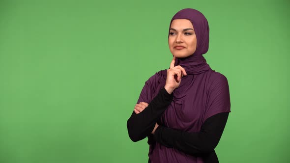 A Young Beautiful Muslim Woman Nods at the Camera with a Smile  Green Screen Background