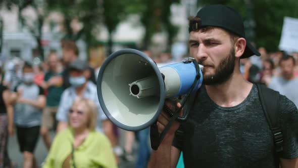 Angry Protester with Bullhorn Walks and Talks