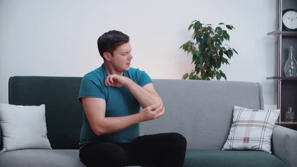 Caucasian man feels pain on his elbow. Muscle and joint pain, health care concept