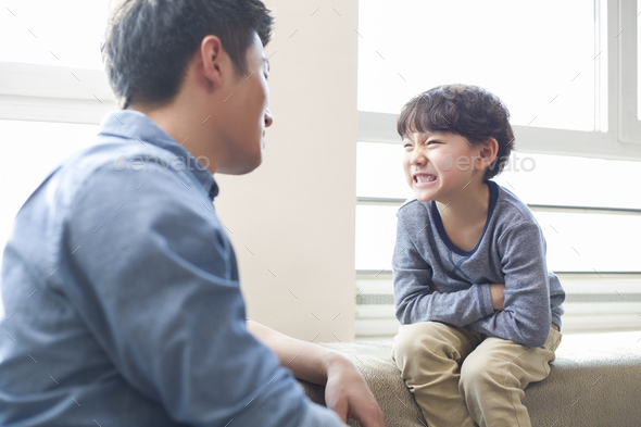 Humorous young father and son - Stock Photo - Images