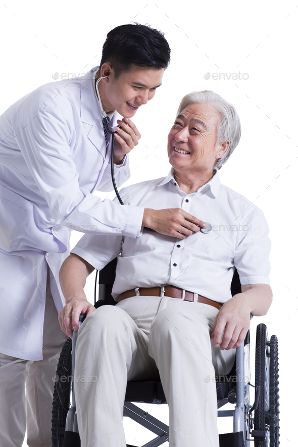 Doctor listening to wheelchair bound patient\'s heart