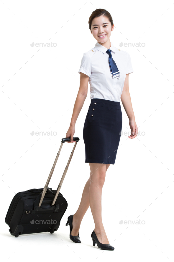 Smiling airline stewardess with wheeled luggage