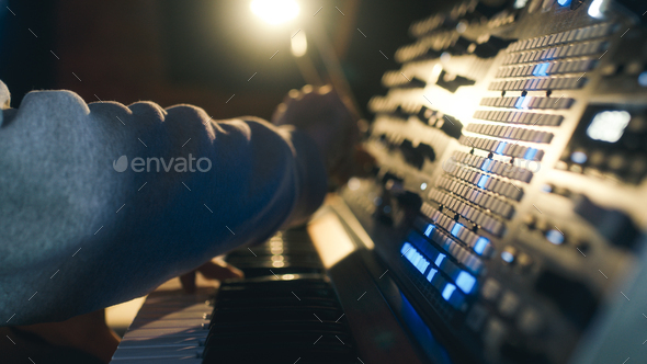 Hands of a man sound engineer are pressing buttons on the console