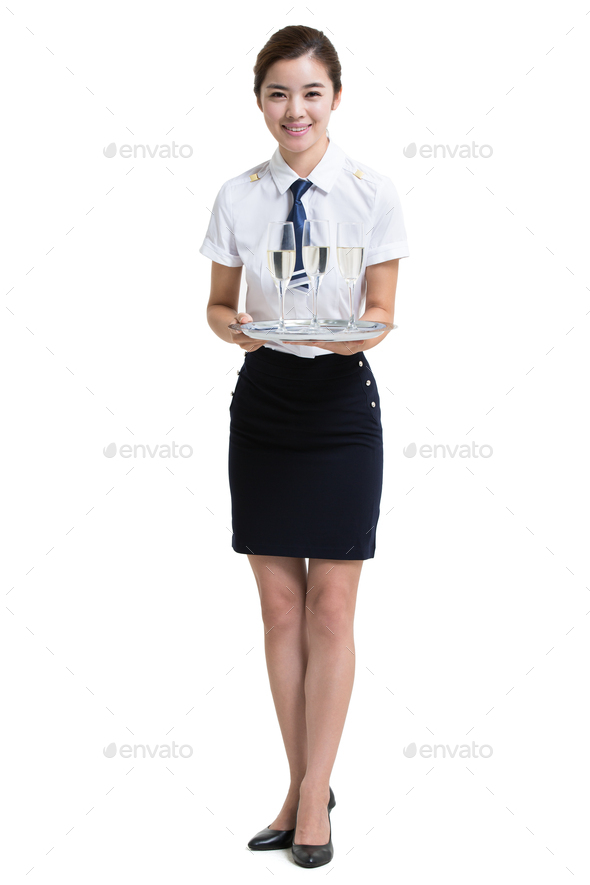 Smiling airline stewardess serving champagne
