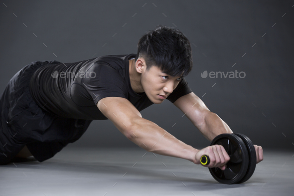 Young man exercising with Ab wheel