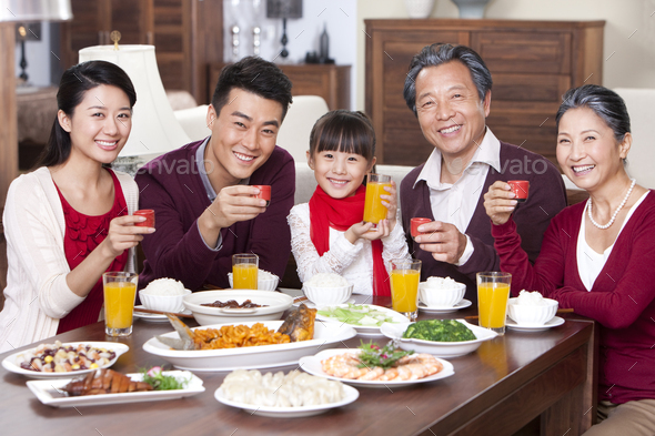 Family toasting at dinner table during Chinese New Year Stock Photo by ...