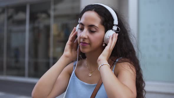 Happy Young Woman Wearing Headphones Listening to Music and Dancing