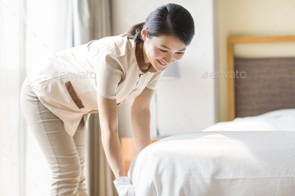Domestic staff cleaning bedroom