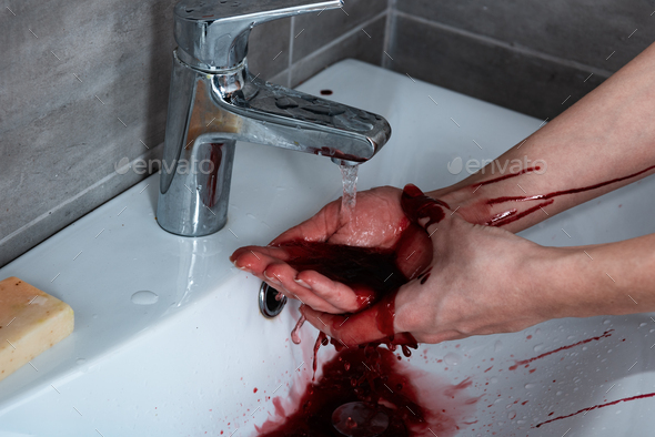 partial view of woman washing bleeding hands in bathroom