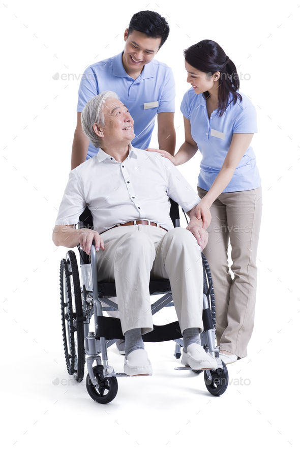 Nursing assistants taking care of senior in wheelchair