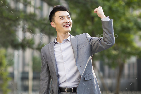 Excited businessman punching the air