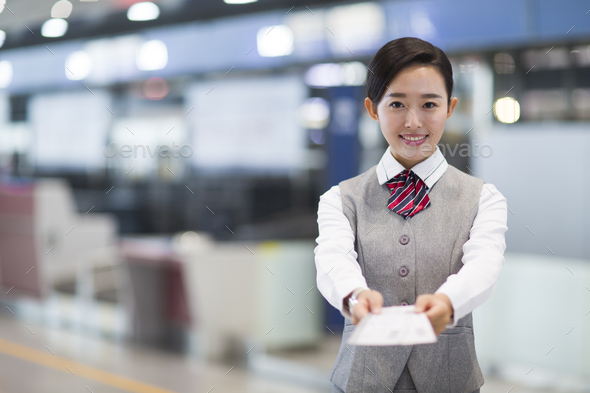 Smiling airline stewardess with airplane tickets