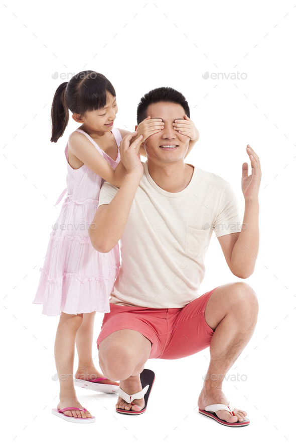 Little girl covering father\'s eyes