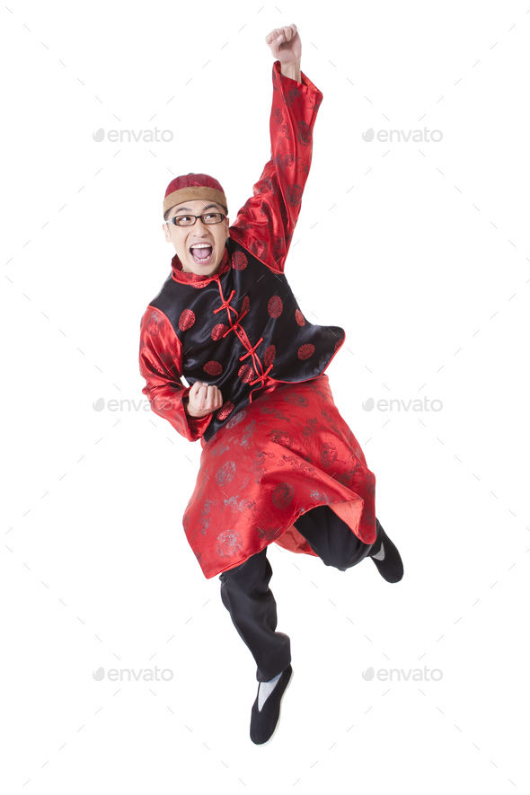 Excited young man in Tang suit punching the air