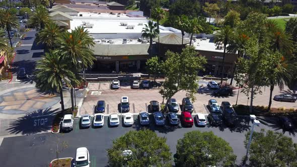 Aerial slow pan and rotation of shopping mall medium level alt