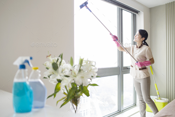 Domestic staff cleaning the window