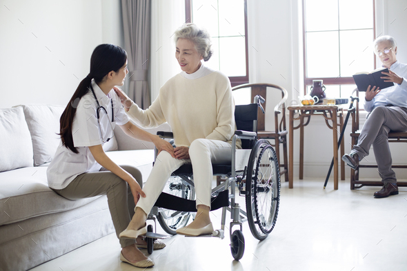 Nursing assistant taking care of senior woman in wheel chair