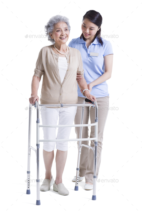 Female nursing assistant helping senior woman with walking frame