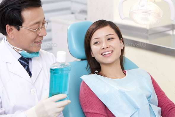 Dentist introducing mouth wash to patient
