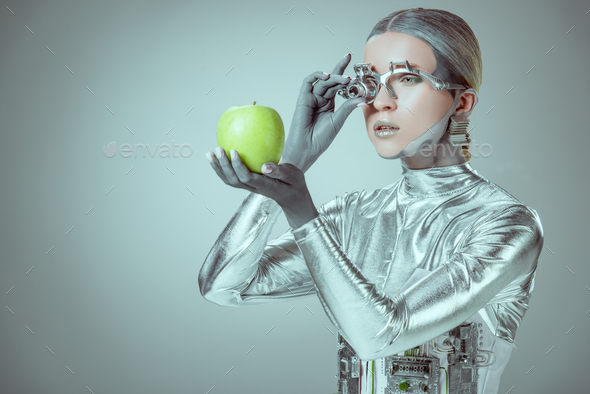 robot examining green apple isolated on grey, future technology concept