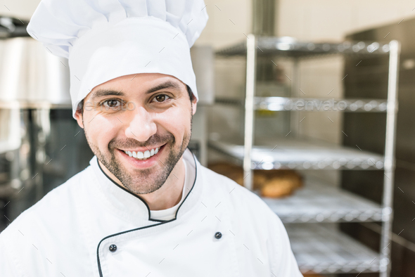 Handsome cook in chefs uniform smiling in bakehouse Stock Photo by ...