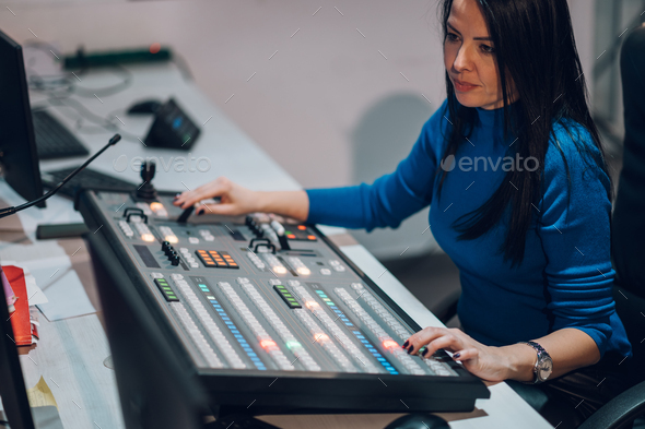 Middle aged woman using equipment in control room on a tv station