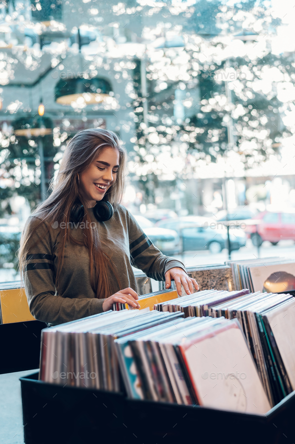 Woman choosing vinyl record in music record shop