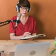 Middle-aged female radio presenter talking into the microphone and reading news - PhotoDune Item for Sale