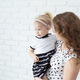 Mother holds her deaf child with hearing aids and cochlear implants - PhotoDune Item for Sale