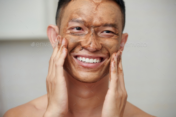 Smiling Man Using Facial Scrub