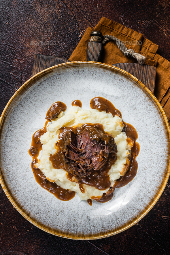 Slow cooked beef cheeks in red wine sauce with mashed potato. Dark